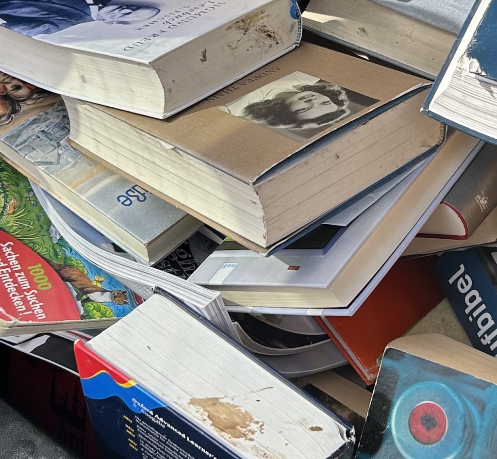 Ein Stapel von vielen Büchern. Alle sind verdreckt und beschädigt.
